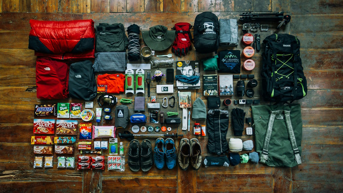Hiking gear laid out on a wooden surface
